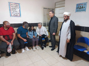 پزشک زندان سلماس در سالن ملاقات خانواده مددجویان را معاینه می کند